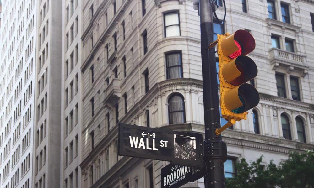 Wall street signpost with iconic yellow traffic signal
