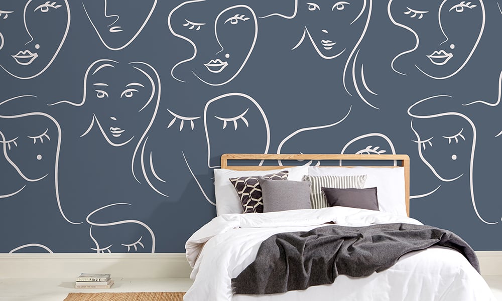 White female faces pattern on blue wallpaper in bedroom - large scale