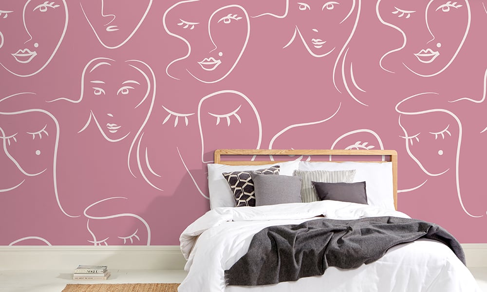 White female faces pattern on pink wallpaper in bedroom - large scale