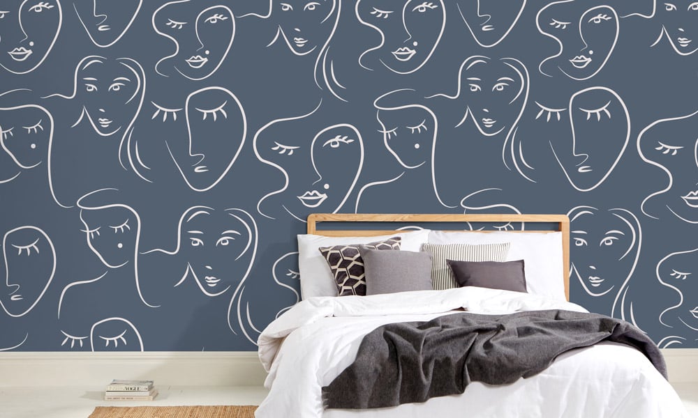White female faces pattern on blue wallpaper in bedroom - medium scale