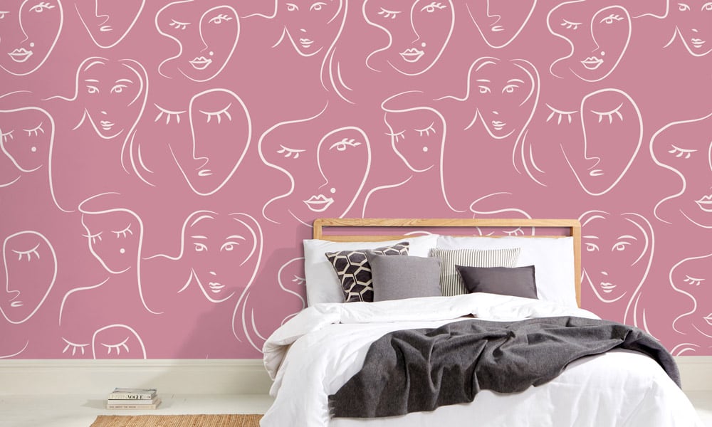 White female faces pattern on pink wallpaper in bedroom - medium scale
