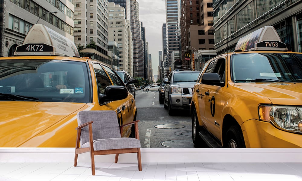 Grey chair in a living room a NYC themed yellow taxi wall mural 
